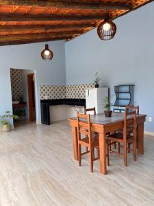 sala de estar con mesa de madera y sillas en Recanto da Roca, en Domingos Martins