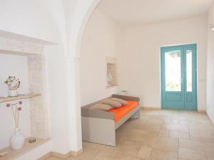 biały pokój z łóżkiem z pomarańczowym kocem w obiekcie Beautiful trulli property with annex in Locorotondo w mieście Locorotondo