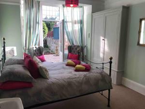 Un dormitorio con una cama con almohadas y una ventana. en Brook Lodge Garden Flat, en Swanage