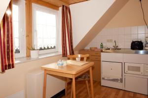 a small kitchen with a wooden table and a sink at Ferienwohnungen Grüne Tanne in Thale
