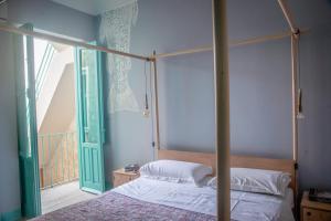 una camera con letto a baldacchino e porta in vetro di Natural House a Favignana