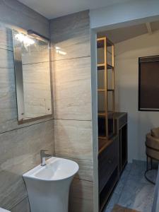 Miracle Hotel and Resorts في كوجيكود: حمام مع حوض ومرآة