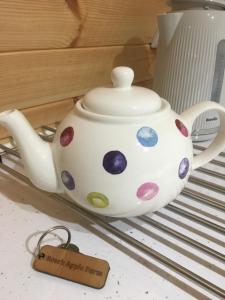 um bule de chá de bolinhas sentado numa prateleira em Orchard Luxe Glamping Pod em Dungannon