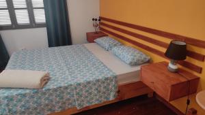 um quarto com uma cama com uma cabeceira de madeira em Rose`s place em Mindelo