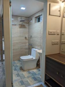 Miracle Hotel and Resorts في كوجيكود: حمام مع مرحاض ودش ومغسلة