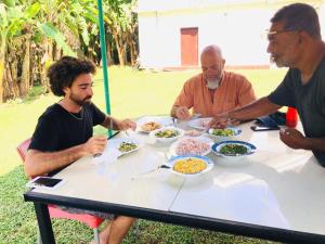 a group of men sitting around a table eating food at Nihal Bay View in Matara
