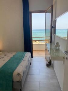 - une chambre avec un lit et une vue sur l'océan dans l'établissement Casa in Salento sul mare con terrazze panoramiche, à Casalabate