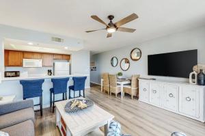 a living room with a couch and a kitchen with a flat screen tv at DW-Sandpiper 407-Resort Style Condo w/ Great Views in Fort Walton Beach
