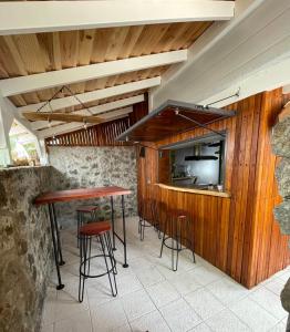 a bar with wooden walls and stools at Le ti Kabanon Du Lagon in La Saline les Bains
