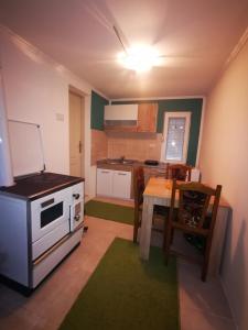 a kitchen with a stove and a table with chairs at Vila Jotic, Zavojsko jezero in Pirot