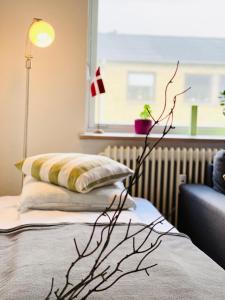 a bedroom with a bed with a pillow and a lamp at Randers residence Sankt Andreas - 2 room apartment in Randers