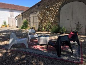 eine Gruppe von Stühlen, die auf einem Teppich im Hof sitzen in der Unterkunft Maison circé in Loupiac-de-Cadillac