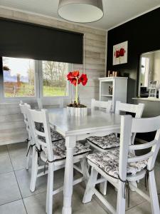 a dining room with a white table and white chairs at Le Chalet de Marguerite in Francorchamps