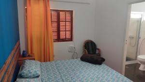 una camera con letto, servizi igienici e finestra di Rose`s place a Mindelo