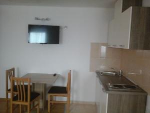 a small kitchen with a table and a sink at Apartments Dale in Plitvička Jezera
