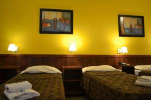 Habitación de hotel con 2 camas y pared amarilla en HOTEL SIENa en Buenos Aires