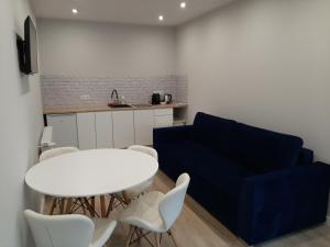 salon z białym stołem i niebieską kanapą w obiekcie Central Platinum Apartments 24 w Rybniku