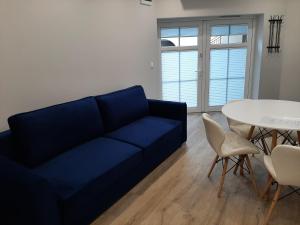 salon z niebieską kanapą i stołem w obiekcie Central Platinum Apartments 24 w Rybniku