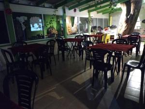 a restaurant with wooden tables and chairs in a room at ALOHA HOSTEL by BUDA BEACH in Puerto Pirámides