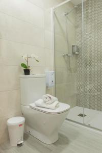 uma casa de banho branca com um WC e um chuveiro em Bilbao ROOMS & KITCHEN Zorroza em Bilbao