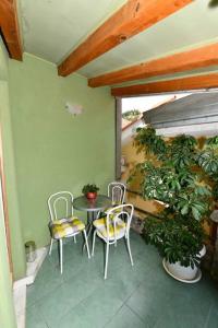 patio z 2 krzesłami, stołem i roślinami w obiekcie Vila NANA w mieście Sinj