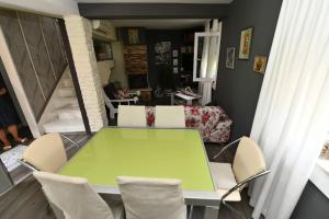 Vila NANA في سيني: غرفة طعام مع طاولة خضراء وكراسي