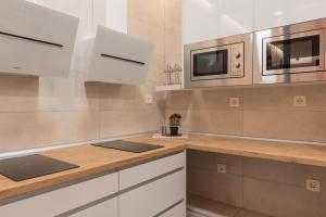 a kitchen with white cabinets and a microwave at Bilbao ROOMS & KITCHEN Zorroza in Bilbao