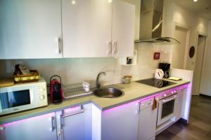 kuchnia z białymi szafkami, zlewem i kuchenką mikrofalową w obiekcie Ref JUAS - Palmes d'Or Properties w Cannes +5 zdjęć