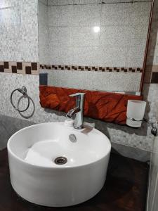 lavabo blanco en el baño con espejo en Ensueño del alma en Villa Pehuenia