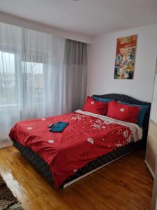 a bed with red pillows and a red blanket at Marya's in Râmnicu Vâlcea