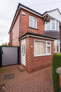 a brick house with a white door at OAKWOOD HOUSE Detached home in South Leeds in Leeds