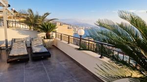 balcón con bancos y vistas al océano en Pirro Luxury Apartment, en Sarandë