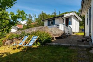 dos sillas sentadas en el patio de una casa en Fantastisk sjøhytte, 10 sengeplasser, strand og egen brygge, en Fredrikstad