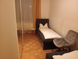 a bed and a chair in a small room at Ferienwohnung Innenstadt in Görlitz