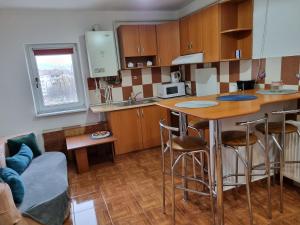 a kitchen with a counter and a kitchen island with bar stools at Marya's in Râmnicu Vâlcea