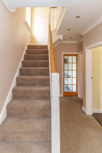 una escalera en una casa con una barandilla de escalera blanca en OAKWOOD HOUSE Detached home in South Leeds, en Leeds