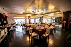 a dining room with tables and chairs and chandeliers at Hotel Inglaterra in Tampico