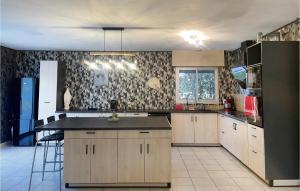 a kitchen with wooden cabinets and a black counter top at Amazing Home In Saint-Vivien-De-Medoc in Saint-Vivien-de-Médoc