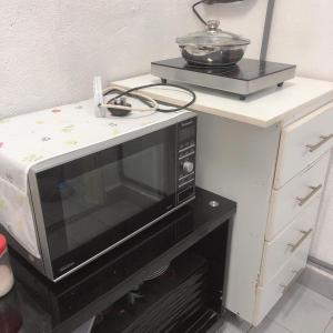 eine Mikrowelle auf einer Theke in der Unterkunft Arena Green Stadium Bukit Jalil furnished, air con all rooms in Kuala Lumpur