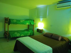 a bedroom with two bunk beds and a light on the wall at ALOHA HOSTEL by BUDA BEACH in Puerto Pirámides