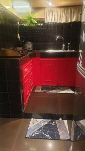 a kitchen with red cabinets and a sink at Billgren House in Imus