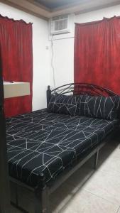Bett in einem Zimmer mit roten Vorhängen in der Unterkunft Billgren House in Imus