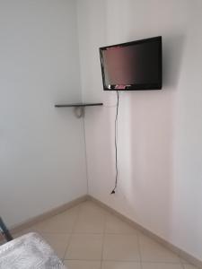 TV de pantalla plana en la pared de una habitación en Appartement Résidence Les Eucalyptus, en LʼÎle-Rousse