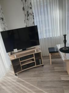 a flat screen tv sitting on a stand in a living room at Maje Am alten Binnenhafen in Emden