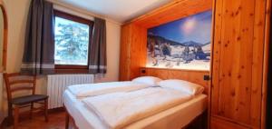 una camera da letto con un letto e una grande finestra di Residence Bait da Mott a Livigno