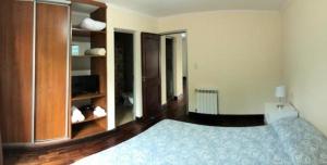 1 dormitorio con 1 cama azul y armarios de madera en Departamento Caseros Desings en Salta