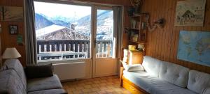 a living room with a couch and a large window at Studio belle vue sur les montagnes in Le Grand-Bornand