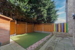 a backyard with a fence and a green lawn at North London Suburbs in Barnet