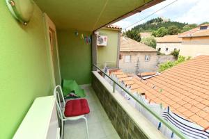 a balcony with red chairs and a view of a roof at Vila NANA in Sinj
