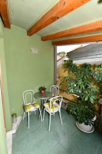 eine Terrasse mit Stühlen, einem Tisch und Pflanzen in der Unterkunft Vila NANA in Sinj